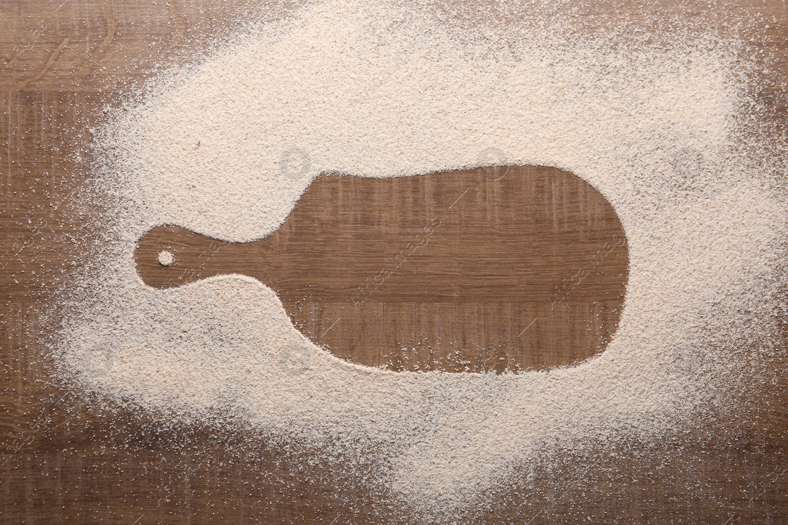 Photo of Imprint of board on wooden table with flour, top view