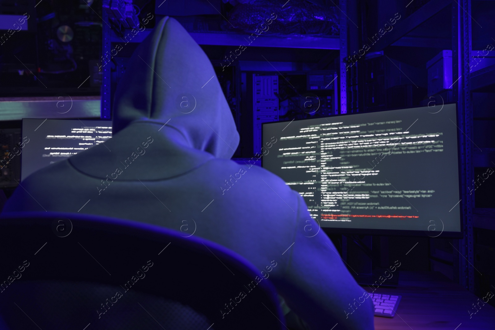 Photo of Hacker working with computers in dark room, back view. Cyber attack