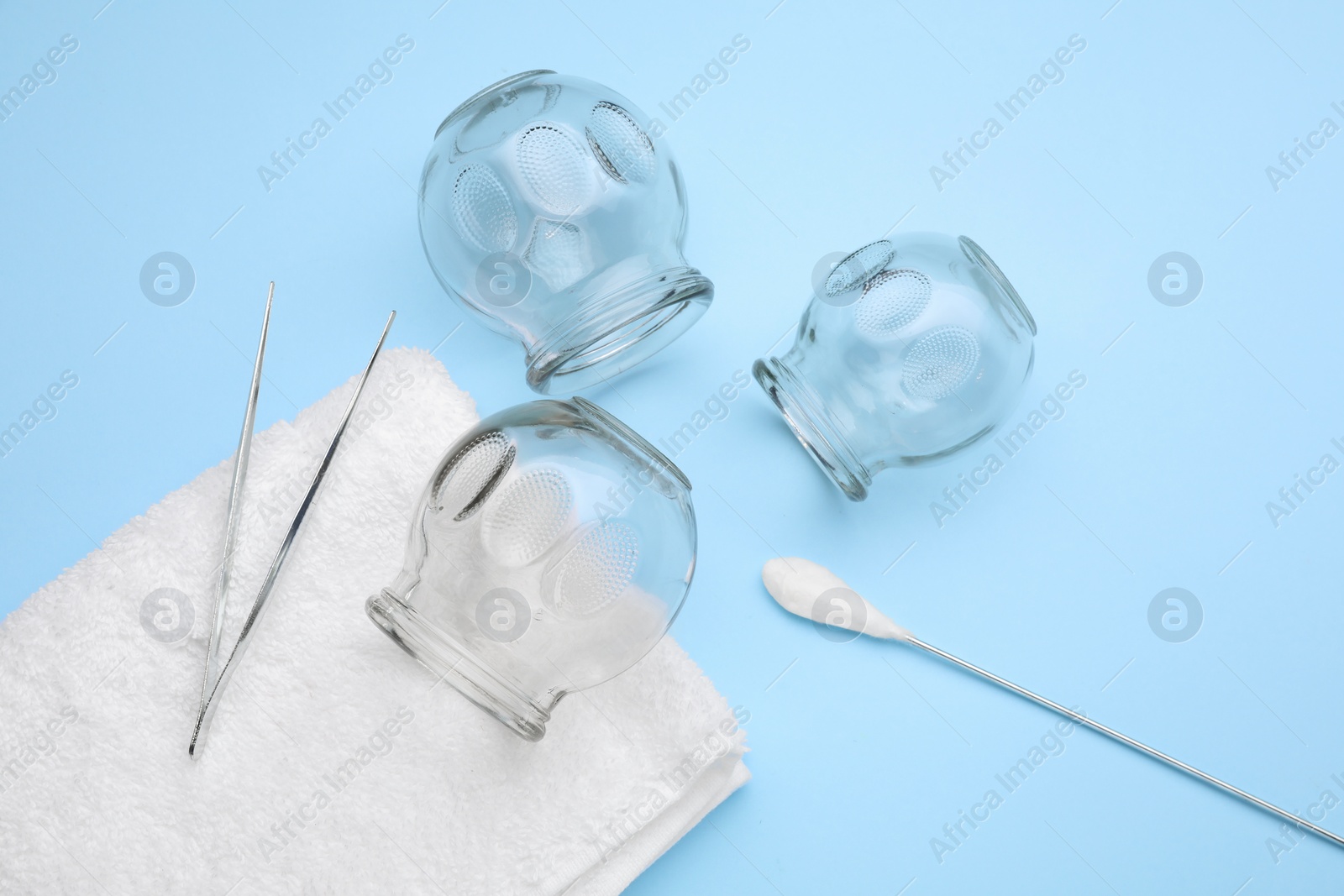 Photo of Flat lay composition with glass cups on light blue background. Cupping therapy