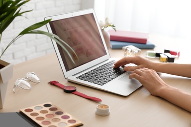 Blogger working with laptop at table, closeup