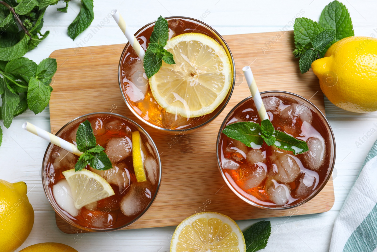 Photo of Flat lay composition with delicious iced tea on white wooden table