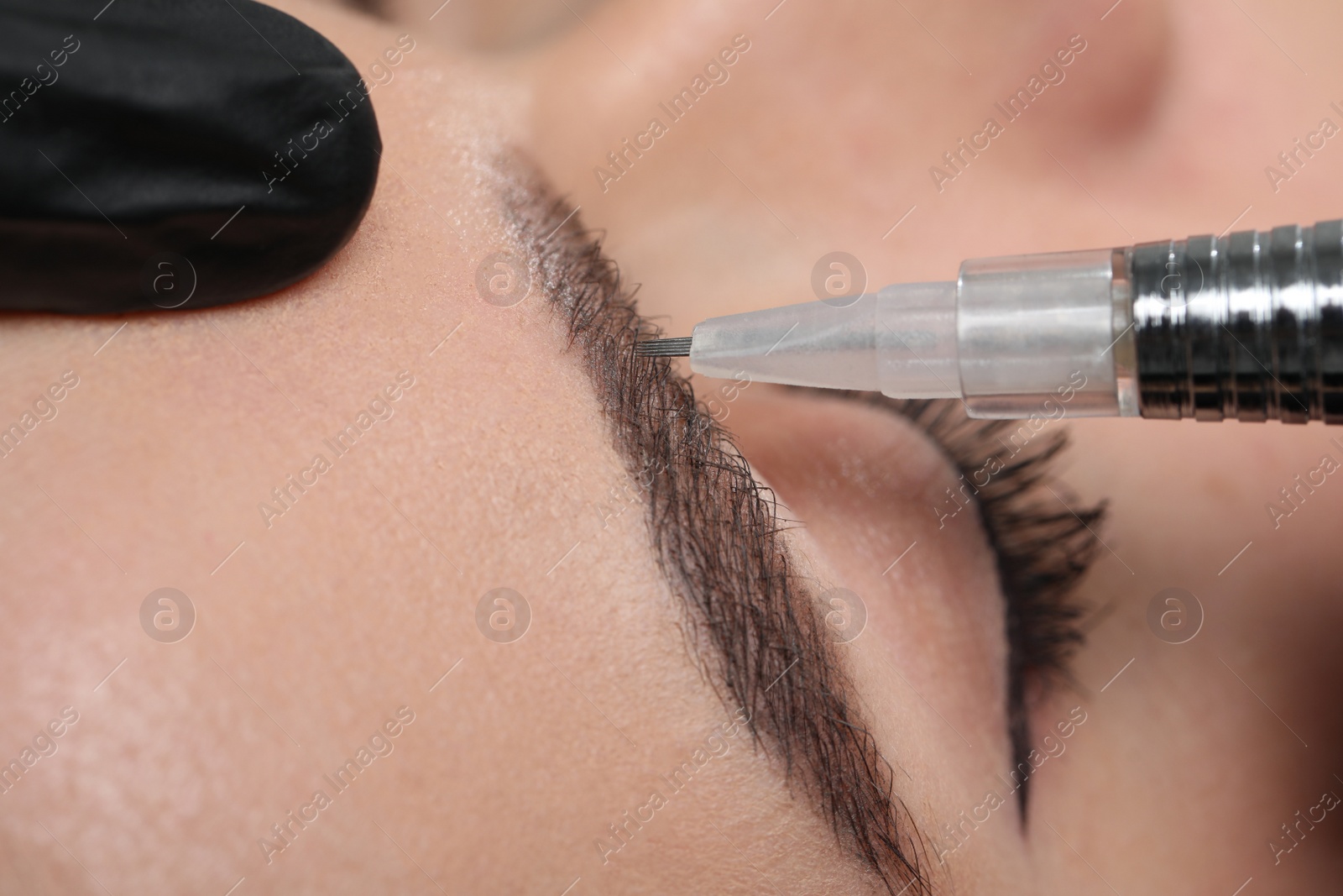 Photo of Young woman during procedure of permanent eyebrow makeup, closeup