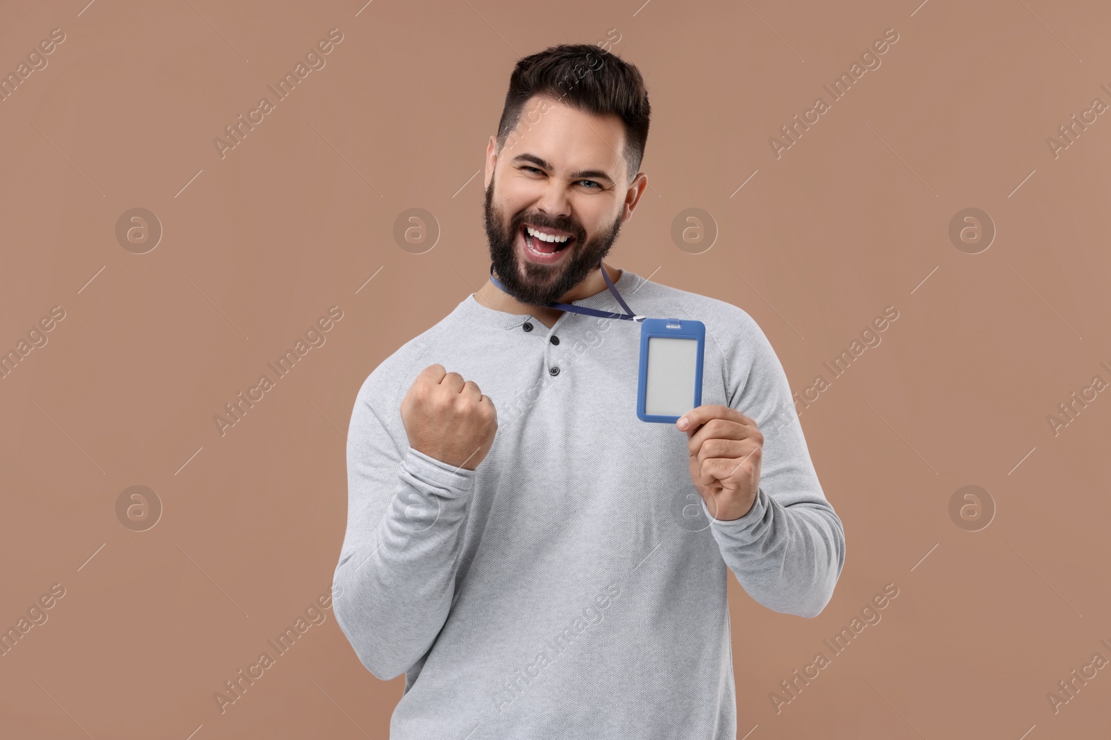 Photo of Happy young man with blank badge on beige background