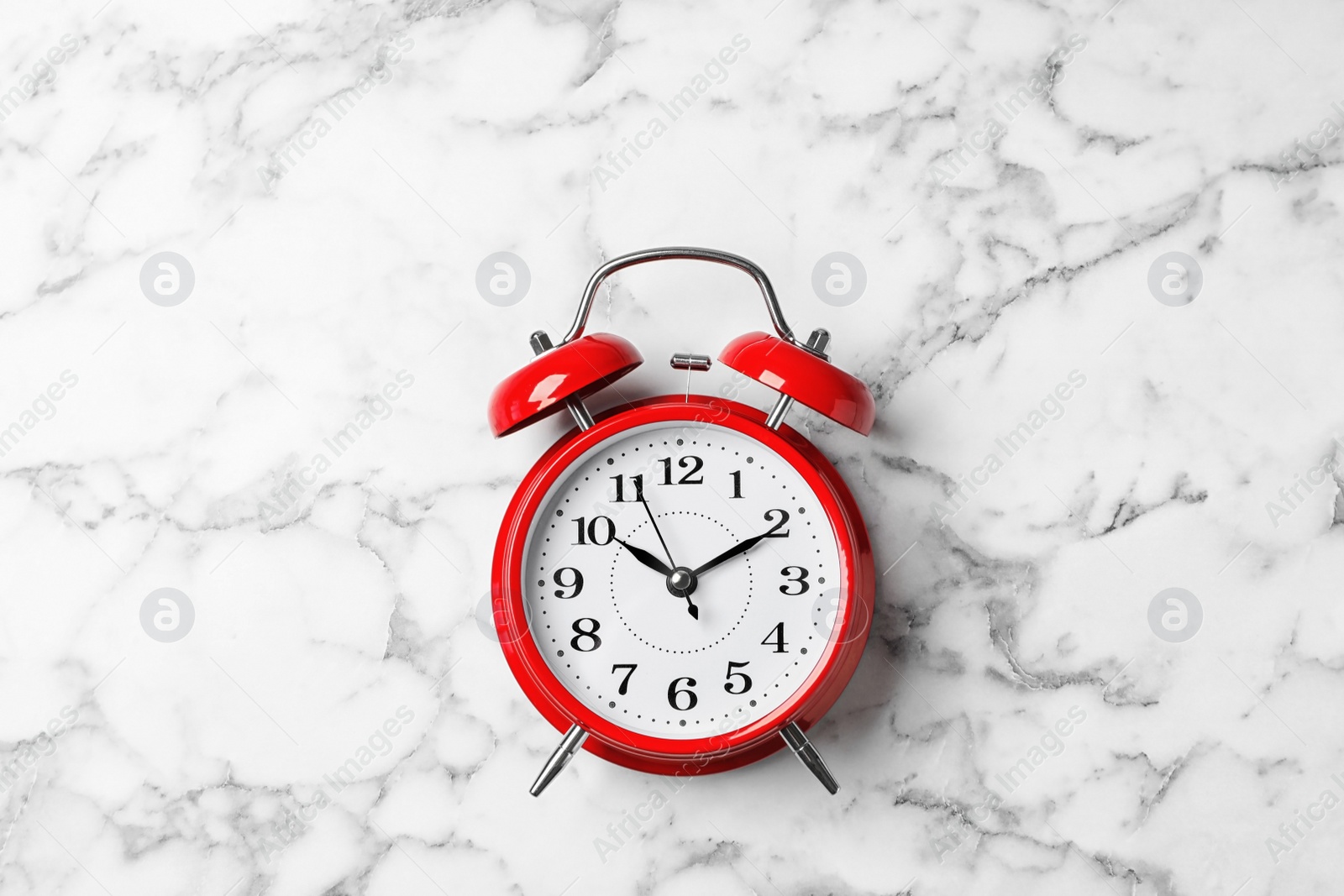 Photo of Alarm clock on marble background, top view. Time management
