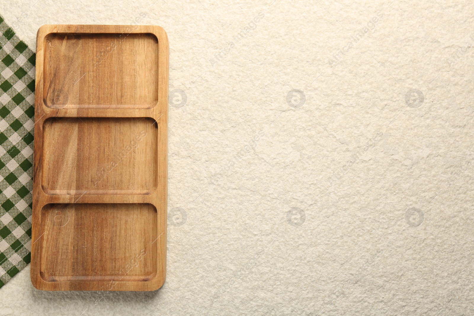 Photo of Wooden serving board on beige table, top view. Space for text