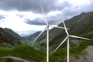 Image of Alternative energy source. Wind turbines and mountains outdoors 