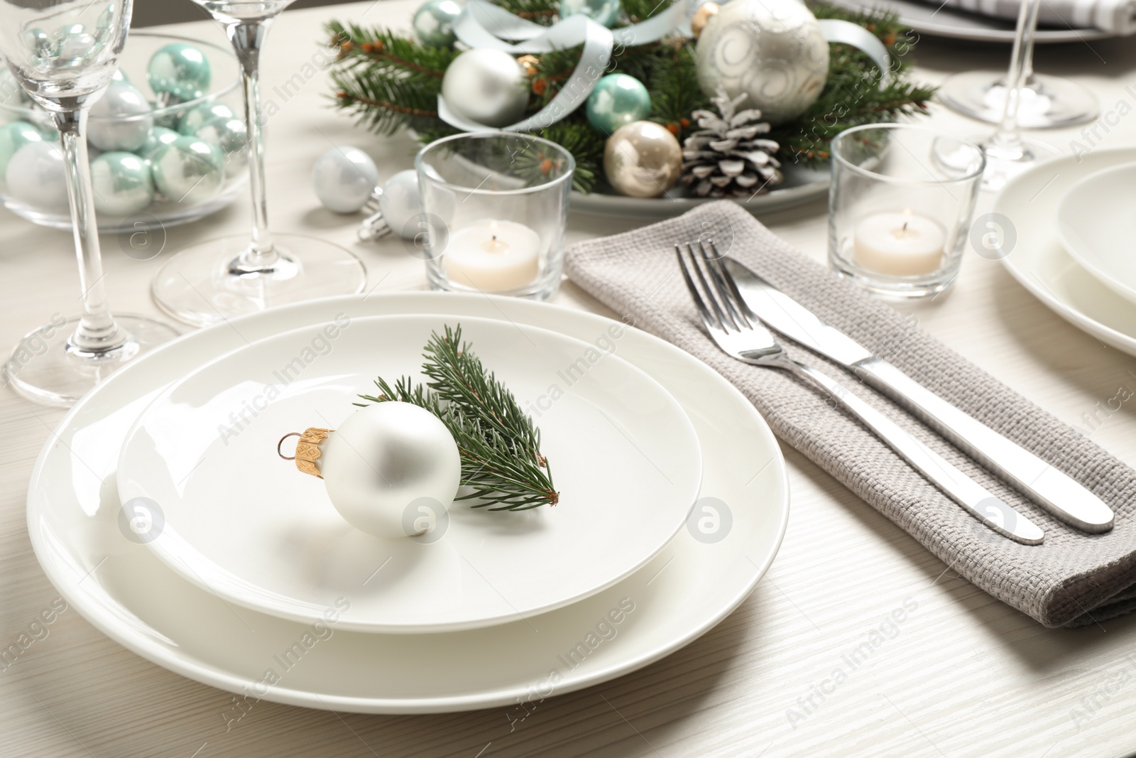 Photo of Festive table setting with beautiful dishware and Christmas decor on white wooden background