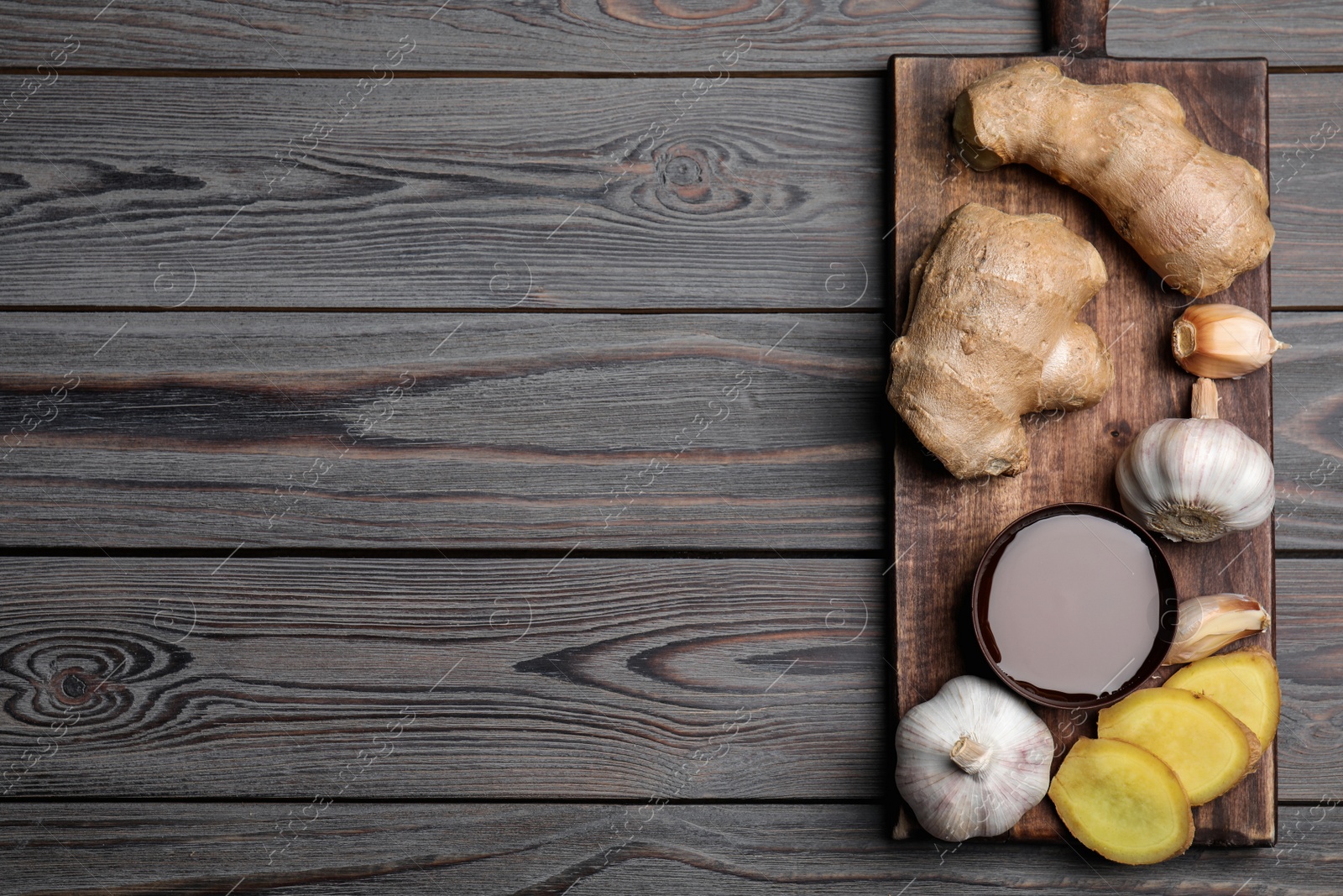 Photo of Fresh garlic and other natural cold remedies on light grey wooden table, top view. Space for text