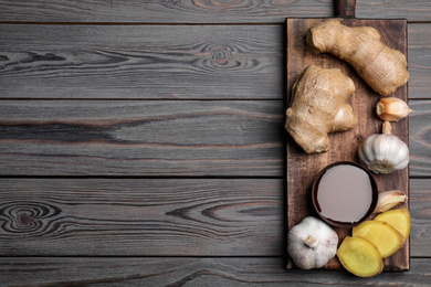 Photo of Fresh garlic and other natural cold remedies on light grey wooden table, top view. Space for text