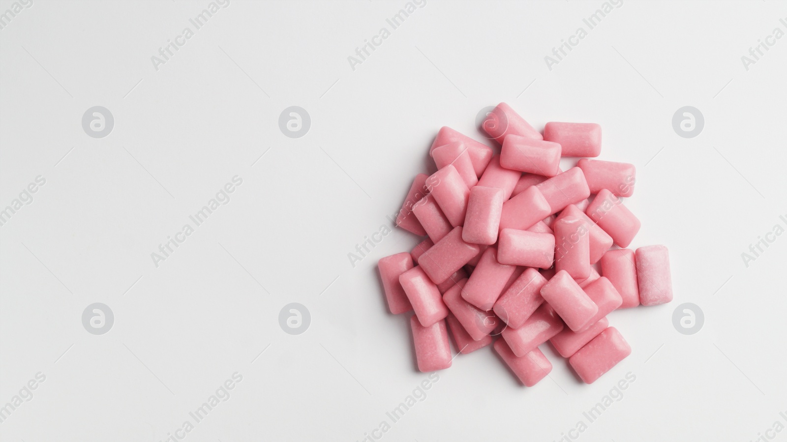 Photo of Sweet chewing gums on white background, top view. Space for text