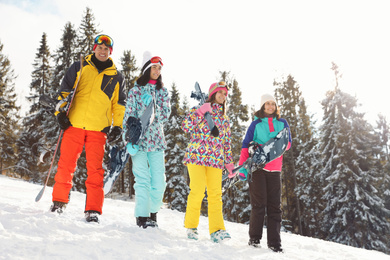Photo of Group of friends with equipment on snowy slope. Winter vacation