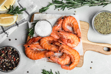 Photo of Delicious cooked shrimps served with lemon and spices on grey marble table, flat lay