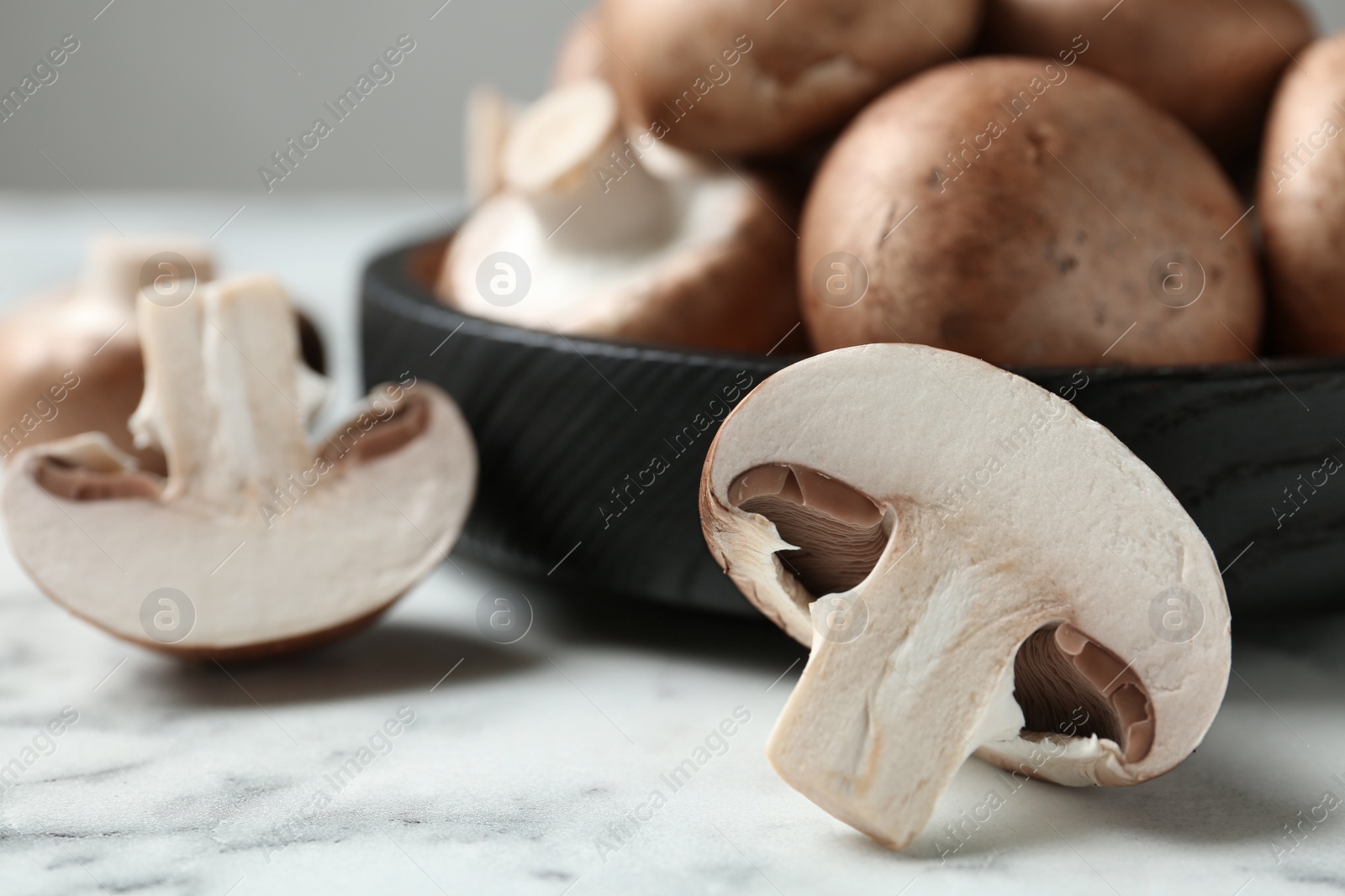 Photo of Fresh champignon mushrooms on marble table, closeup. Space for text