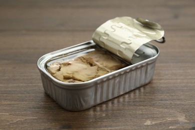 Open tin can of tasty cod liver on wooden table
