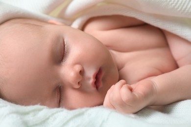 Photo of Cute newborn baby sleeping on white blanket, closeup