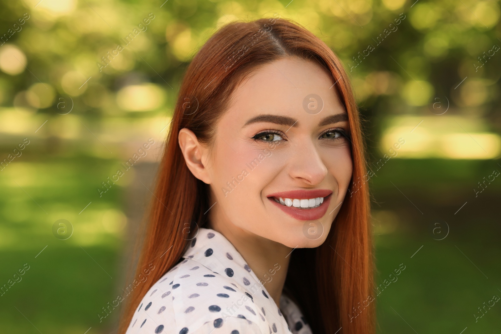 Photo of Portrait of charming young woman with beautiful smile in park. Attractive lady posing for camera