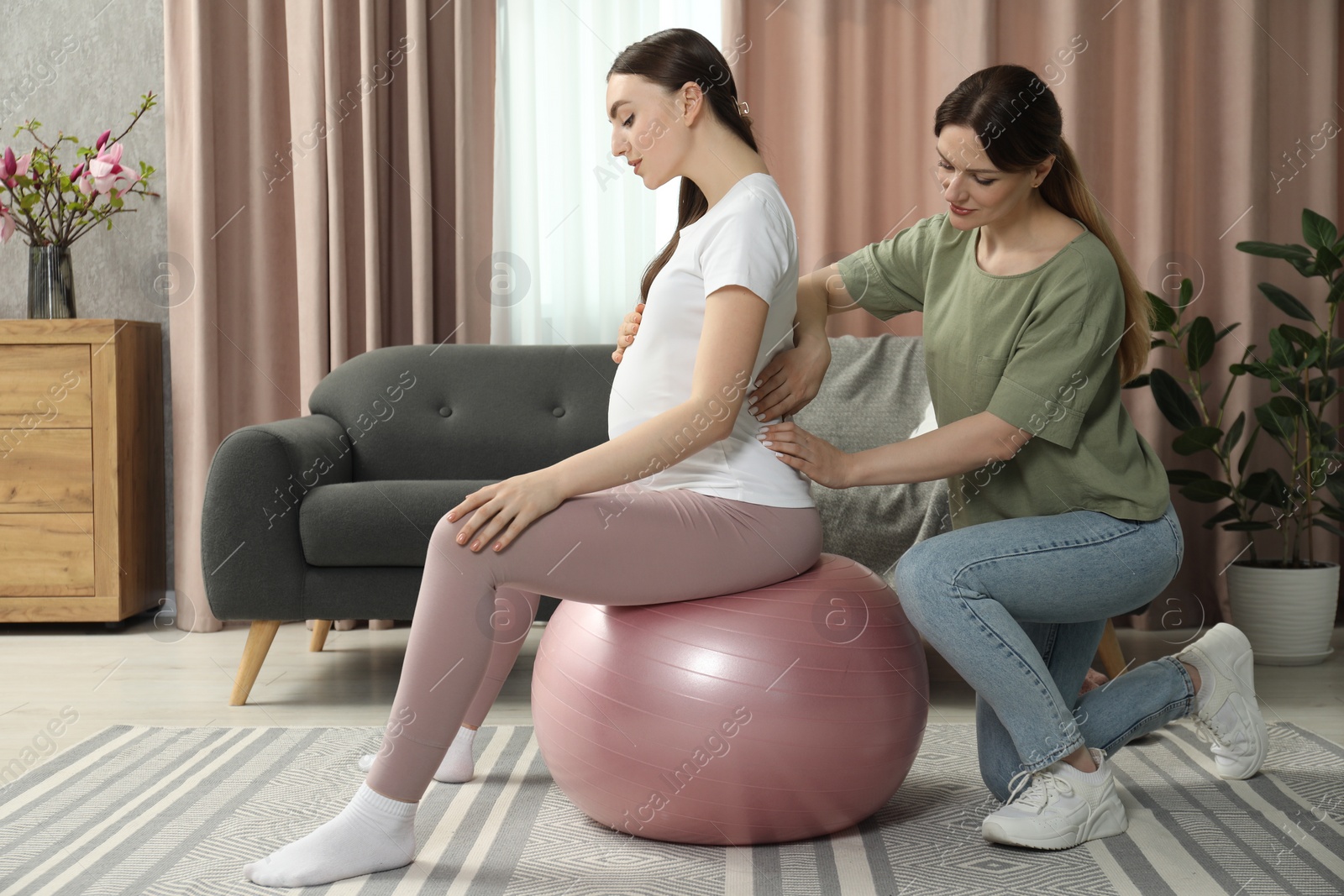 Photo of Doula massaging pregnant woman at home. Preparation for child birth