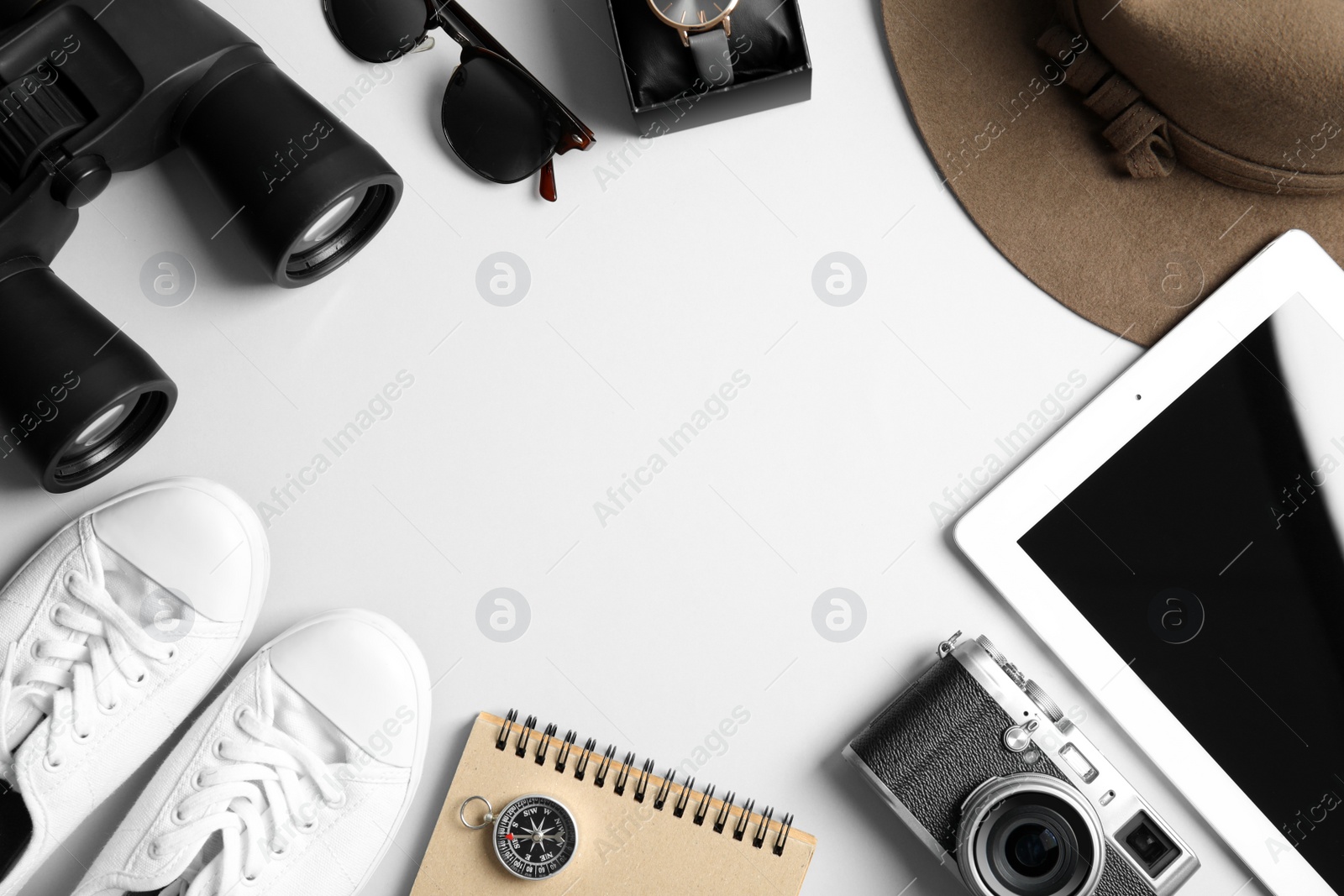 Photo of Flat lay composition with tablet, binoculars and camera on white background, space for text. Travel agency