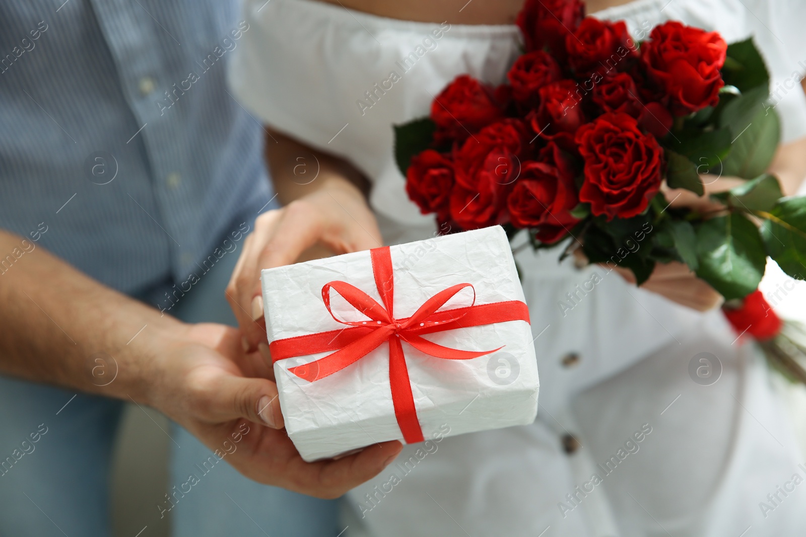 Photo of Man presenting gift to his beloved woman at home, closeup. Valentine's day celebration