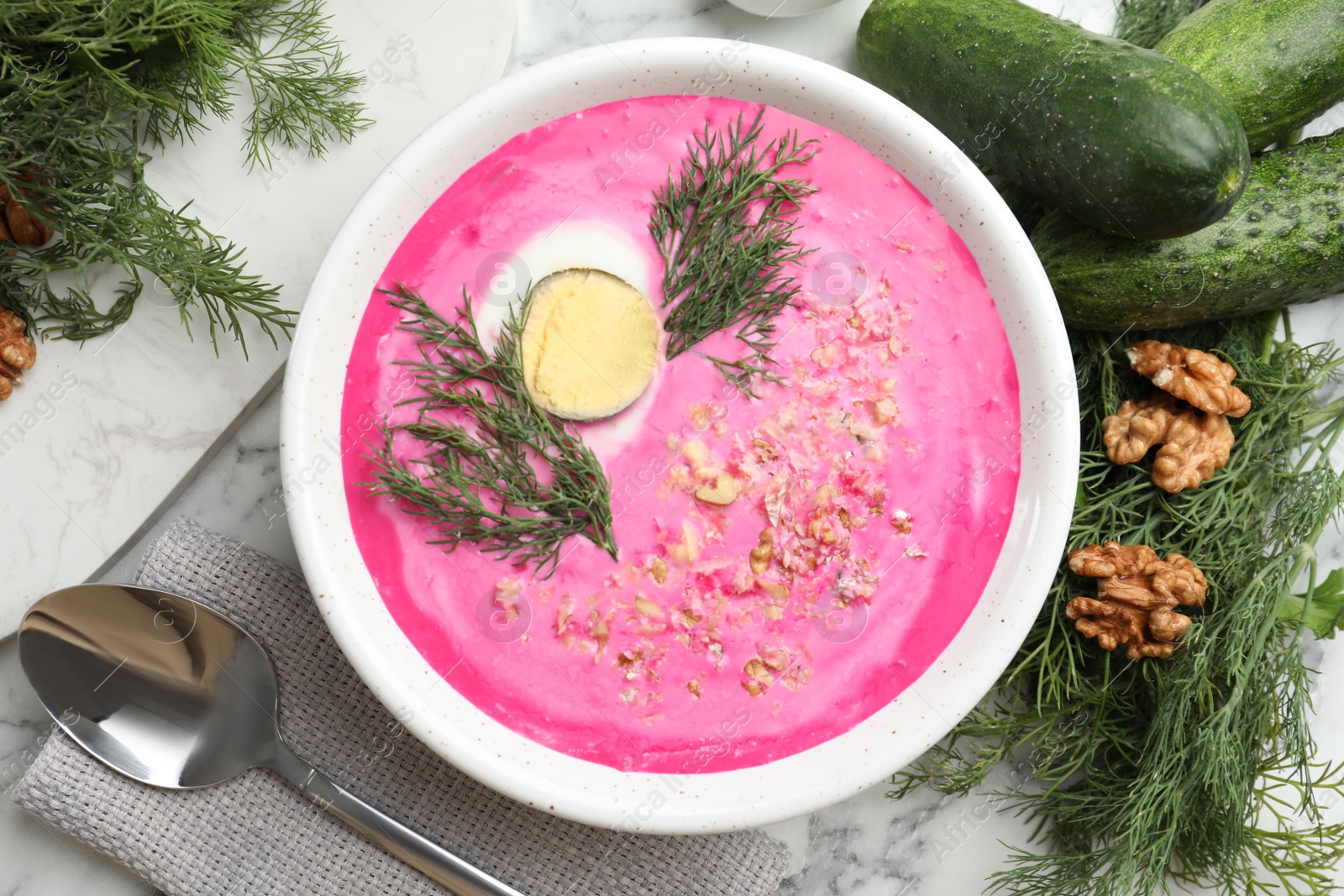 Photo of Delicious cold summer beet soup on white marble table, flat lay