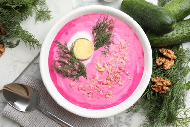 Photo of Delicious cold summer beet soup on white marble table, flat lay