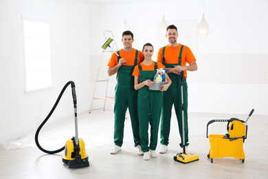 Photo of Team of professional janitors with cleaning supplies indoors