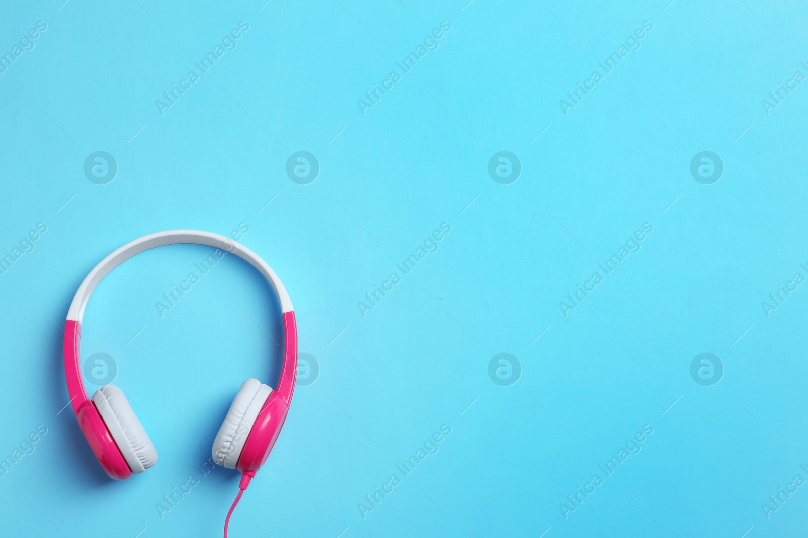 Photo of Stylish headphones on color background, top view. Space for text