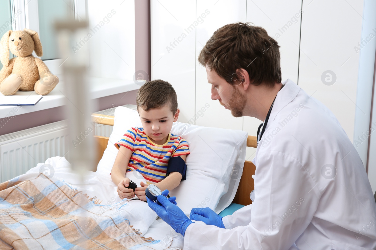 Photo of Doctor checking child's blood pressure in hospital