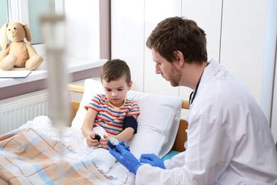 Doctor checking child's blood pressure in hospital
