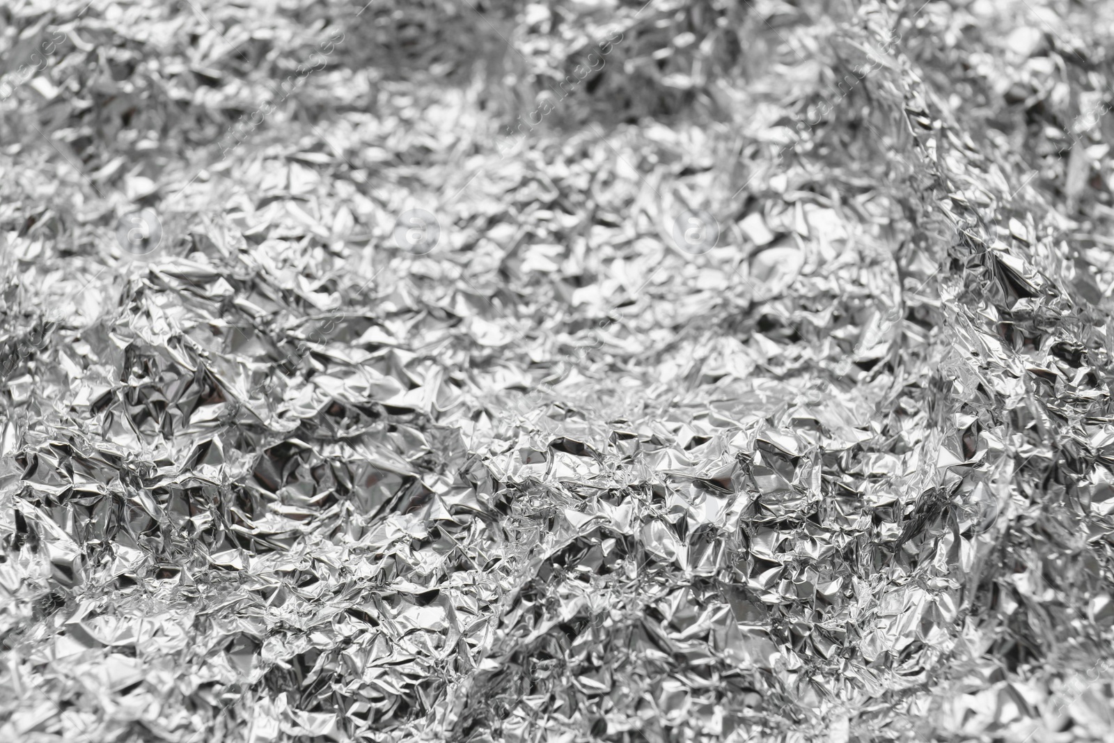 Photo of Crumpled silver foil as background, closeup view