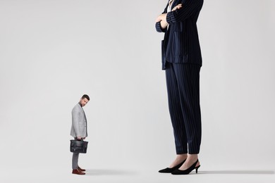 Image of Giant woman and sad small man on light background