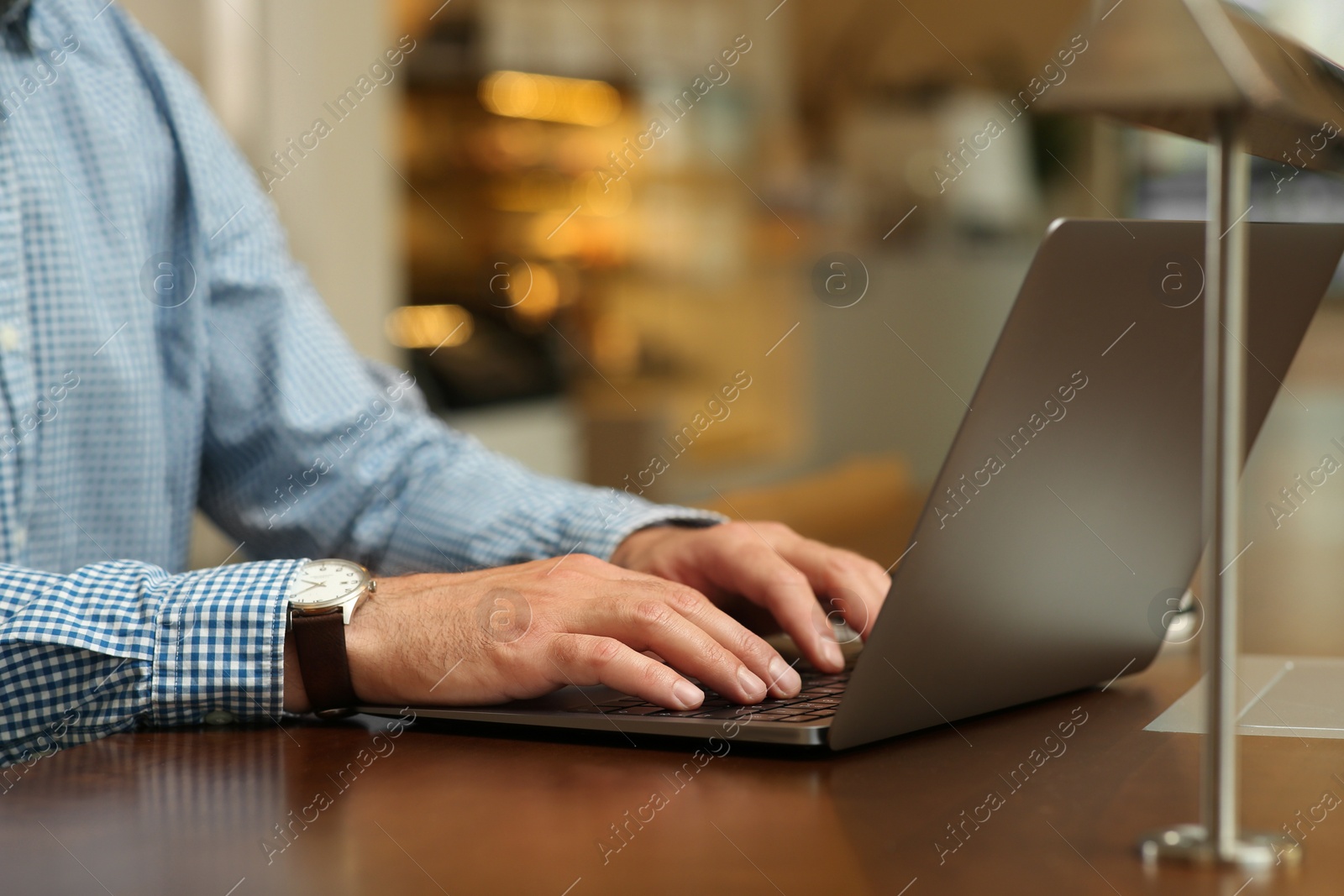 Photo of Man working on laptop at table in cafe, closeup