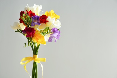 Photo of Beautiful freesia bouquet on grey background