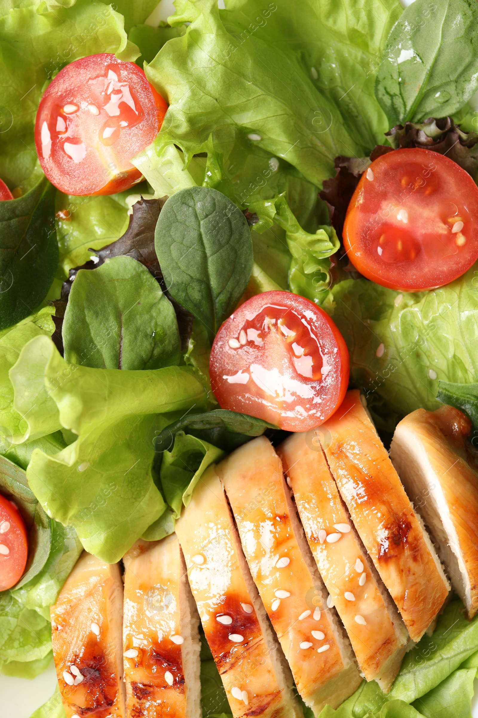 Photo of Delicious salad with chicken, cherry tomato and spinach as background, top view