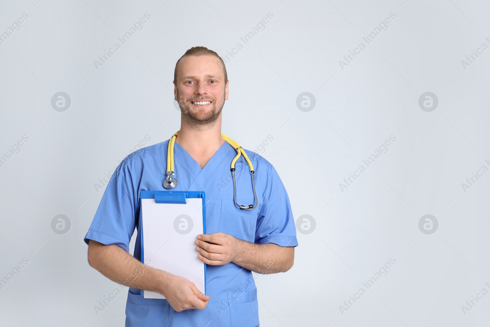 Photo of Portrait of medical assistant with stethoscope and clipboard on color background. Space for text