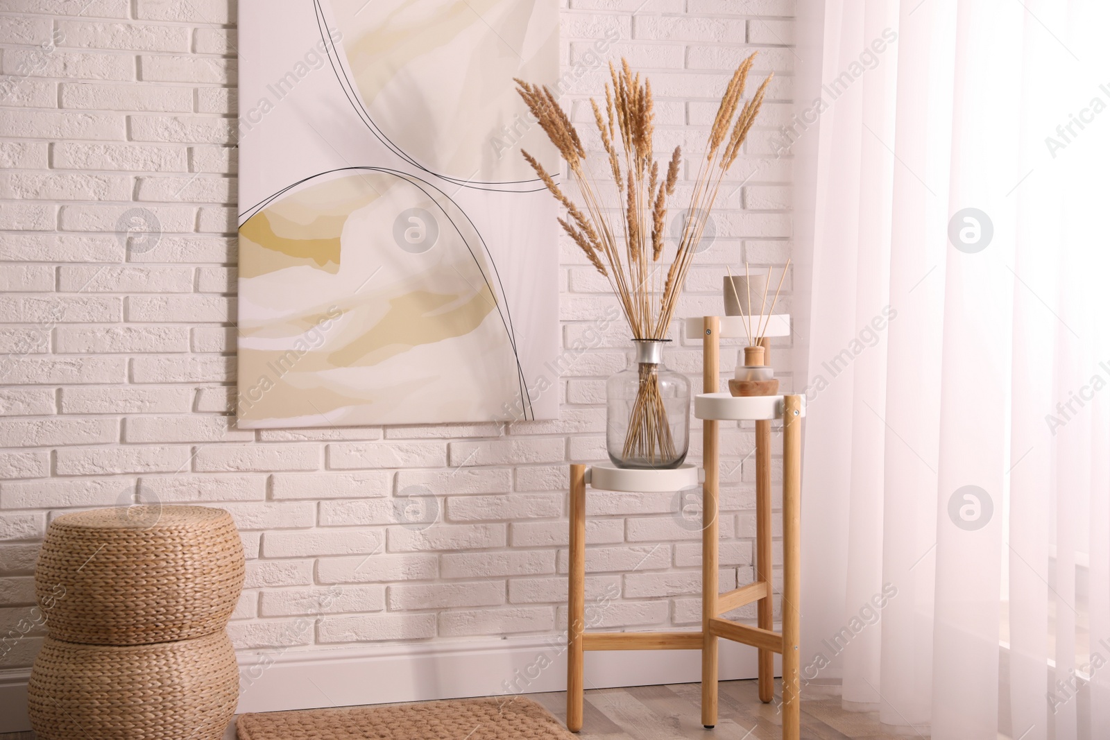 Photo of Fluffy reed plumes and painting in stylish room interior