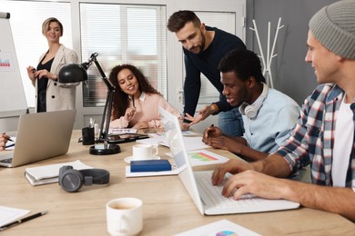 Photo of Team of employees working together in office. Startup project