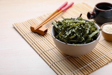 Photo of Fresh laminaria (kelp) seaweed served on wooden table, space for text