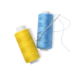 Different colorful sewing threads with needle on white background, top view