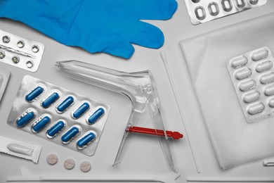 Photo of Sterile gynecological examination kit and medicaments on beige background, flat lay