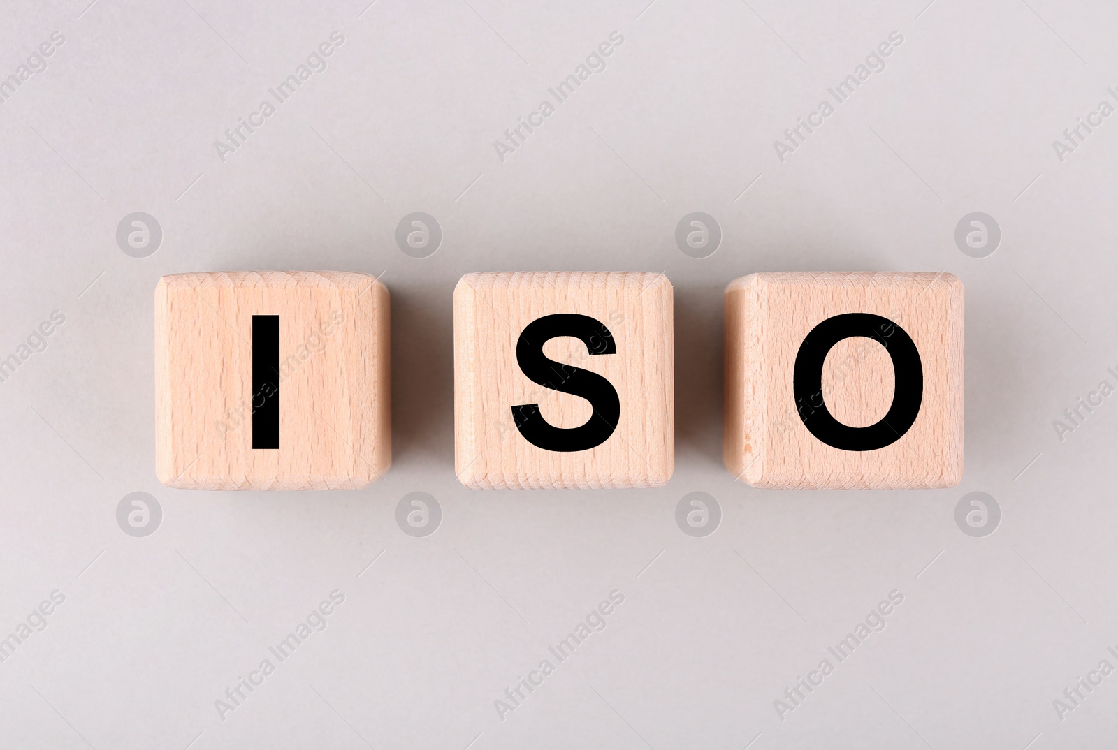 Photo of International Organization for Standardization. Cubes with abbreviation ISO on light grey background, top view