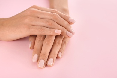 Closeup view of woman with beautiful hands on color background, space for text. Spa treatment