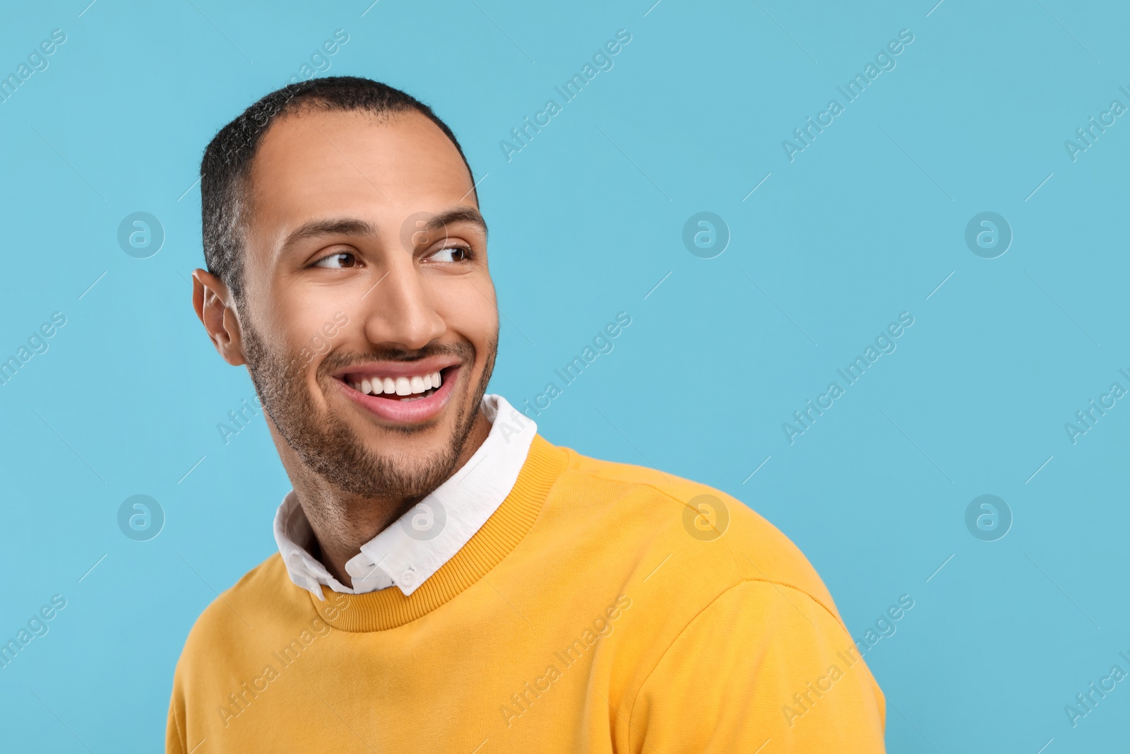 Photo of Smiling man with healthy clean teeth on light blue background. Space for text