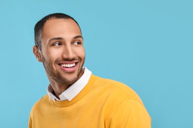 Photo of Smiling man with healthy clean teeth on light blue background. Space for text