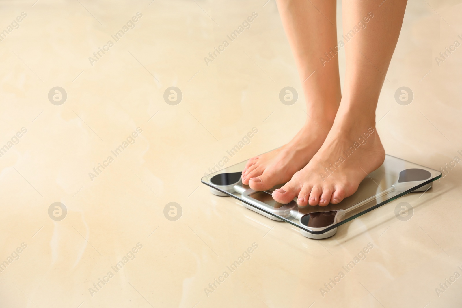 Photo of Woman standing on scales indoors, space for text. Overweight problem