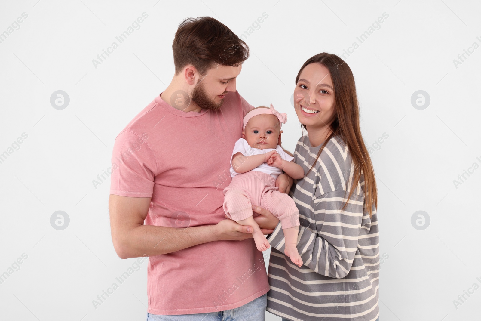 Photo of Happy family. Parents with their cute baby on light background