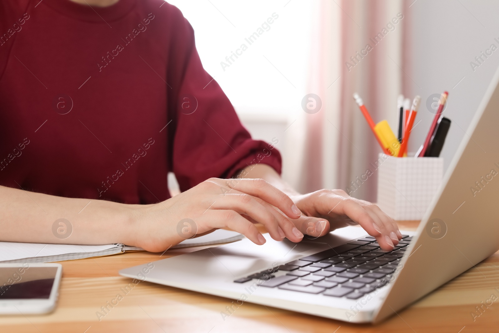 Photo of Young woman working with laptop at desk. Home office