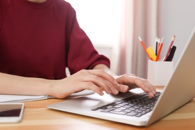 Young woman working with laptop at desk. Home office