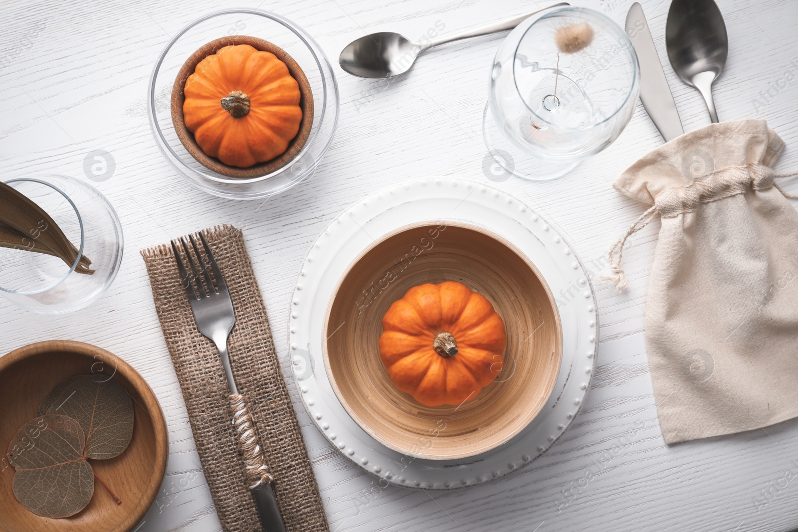 Photo of Autumn table setting with pumpkins on white wooden background, flat lay