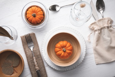 Photo of Autumn table setting with pumpkins on white wooden background, flat lay